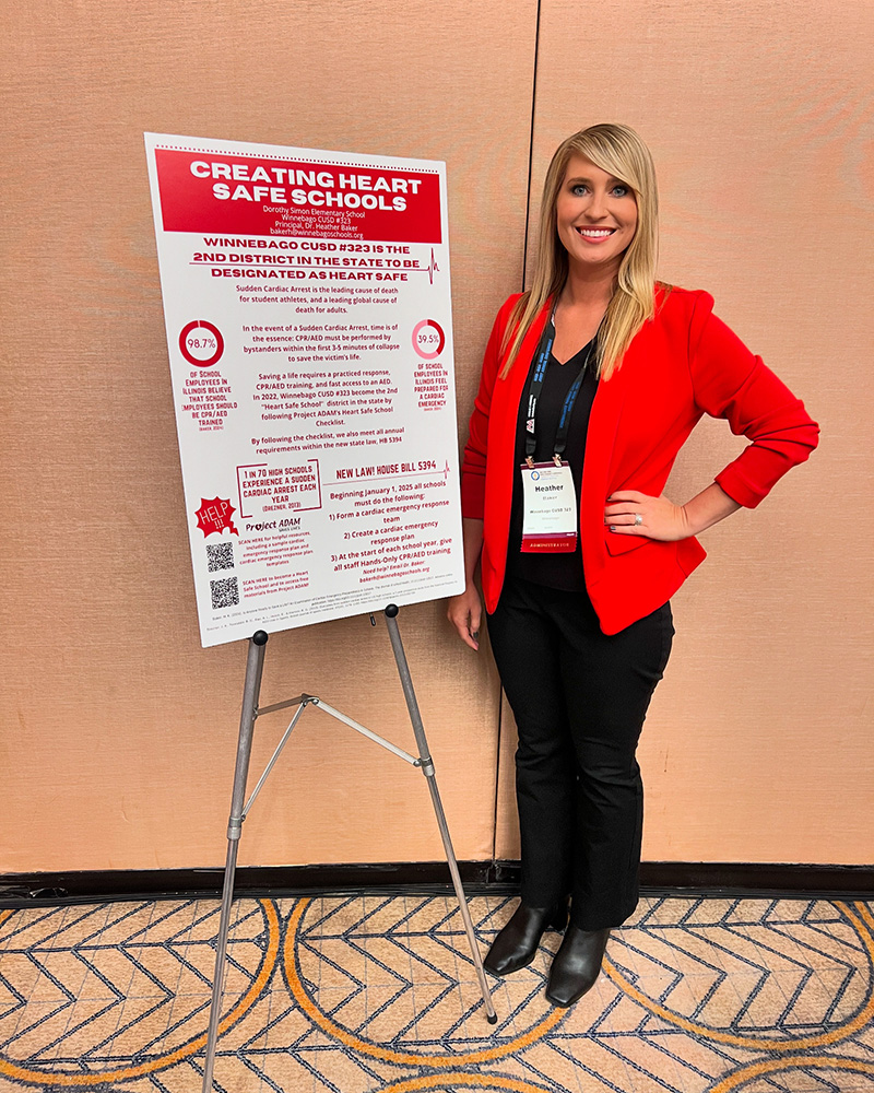 Woman standing next to Heart Safe Schools poster